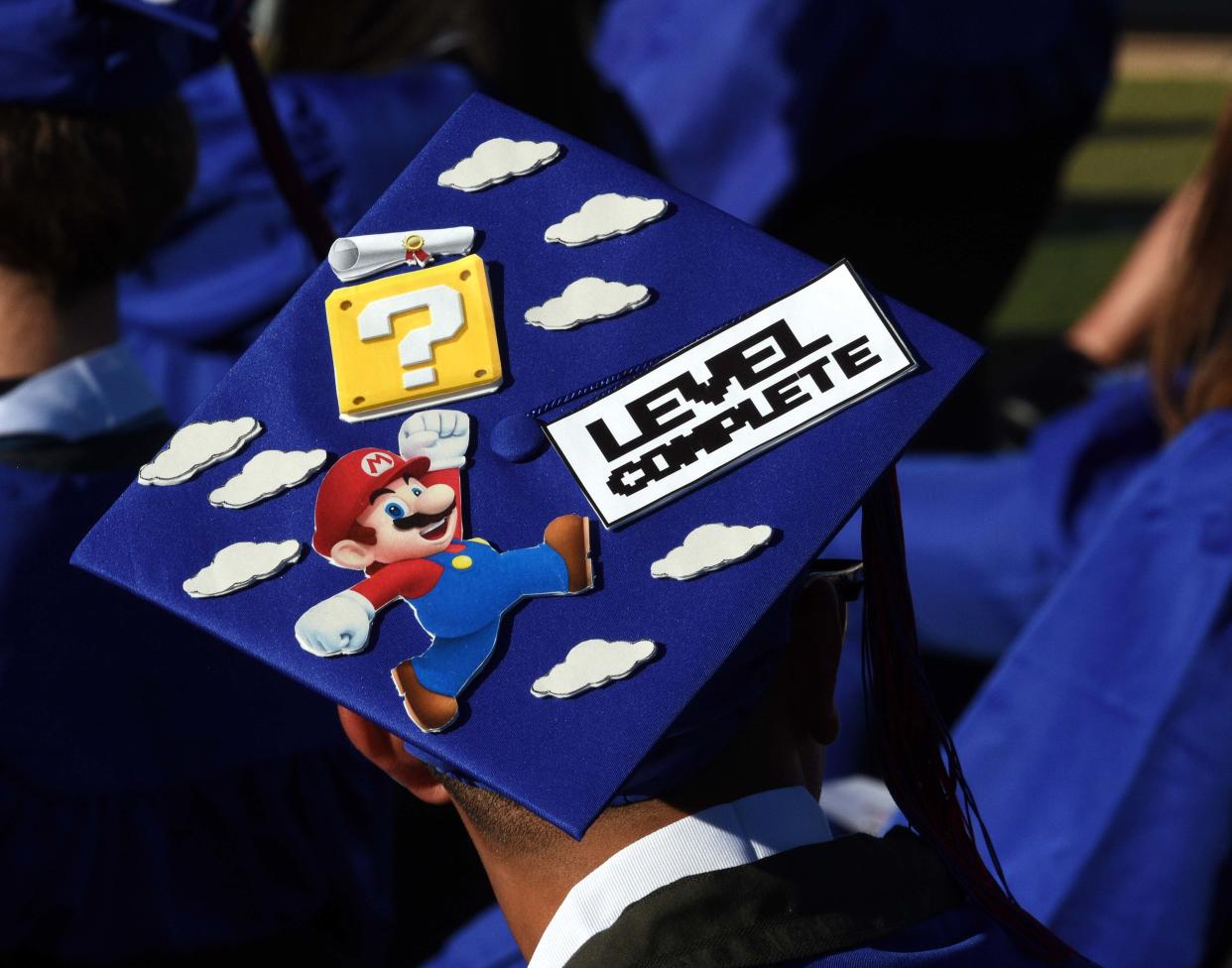 A Las Cruces High School graduate shows off their mortarboard at the Field of Dreams Saturday, May 21, 2022. New Mexico lawmakers and state education officials are looking at overhauling required high school coursework for future graduates.