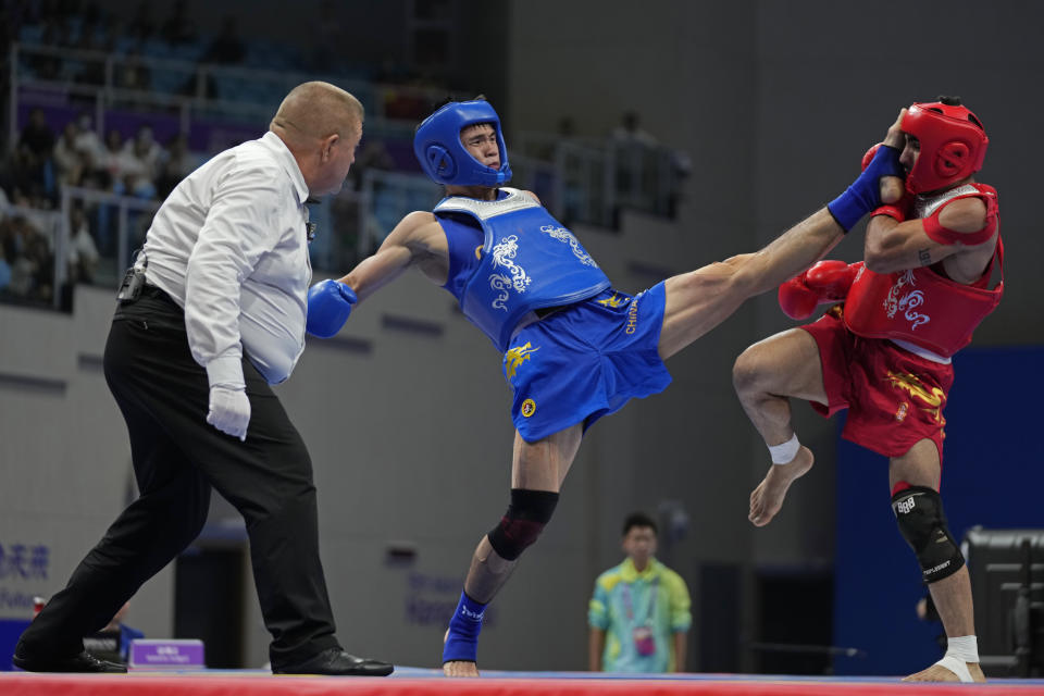 China's Feng He, in blue, fights Iran's Mohsen Mohammadseifi in the Wushu men's 70kg final at 19th Asian Games in Hangzhou, China, Thursday, Sept. 28, 2023. (AP Photo/Aijaz Rahi)