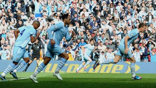 Manchester City's Edin Dzeko (R) runs back to the half-way line after scoring his goal during their English Premier League match against Queens Park Rangers at The Etihad stadium in Manchester, on May 13. Man City won the game 3-2 to secure their first league title since 1968