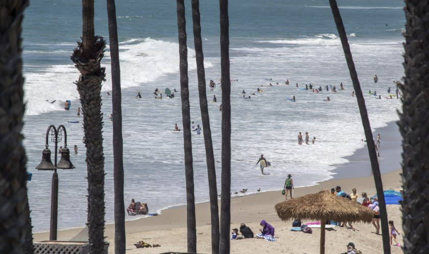 SAN CLEMENTE, CA - JUNE 30: Beach-goers take to the water on a warm summer day at the San Clemente Pier Tuesday, June 30, 2020. Heal the Bay released its annual Beach Report Card and the San Clemente Pier made the top 10 list of beach bummers. (Allen J. Schaben / Los Angeles Times)