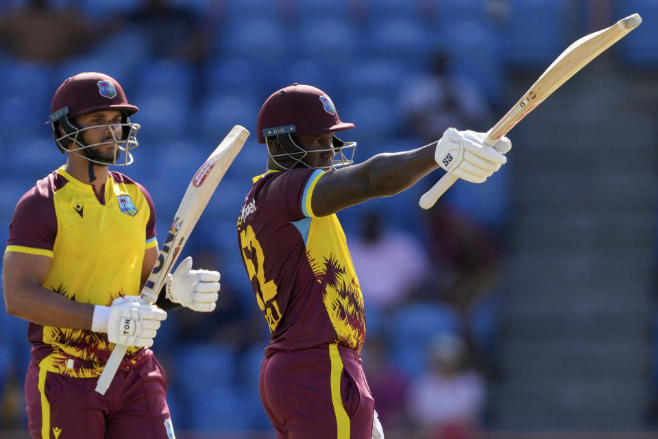 West Indies' captain Rovman Powell celebrates scoring half a century against England during his partnership with Brandon King during the second T20 cricket match at National Cricket Stadium in Saint George's, Grenada, Thursday, Dec. 14, 2023. (AP Photo/Ricardo Mazalan)