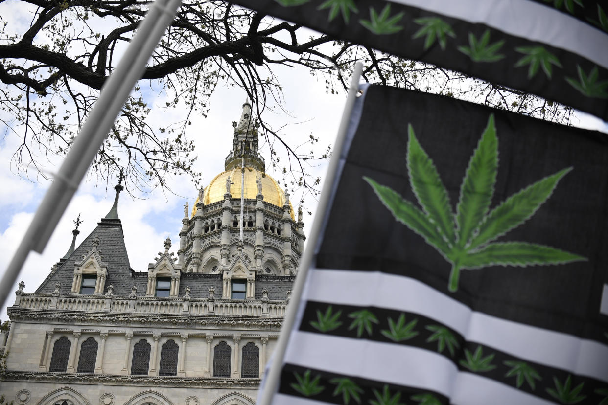FILE - Flags with a marijuana leaf wave outside the Connecticut State Capitol building, Tuesday, April 20, 2021 in Hartford, Conn. Connecticut's first round of retail cannabis sales for adults 21 and older was set to begin Tuesday, Jan. 10, 2023, morning at seven existing medical marijuana establishments across the state, less than two years after Gov. Ned Lamont signed legislation making Connecticut the latest state to legalize recreational sales.(AP Photo/Jessica Hill, File)