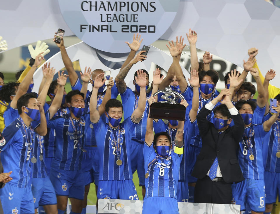 Ulsan Hyundai's players celebrate with a trophy after the AFC Champions League final match against Persepolis in Al Wakrah, Qatar, Saturday, Dec. 19, 2020. (AP Photo/Hussein Sayed)