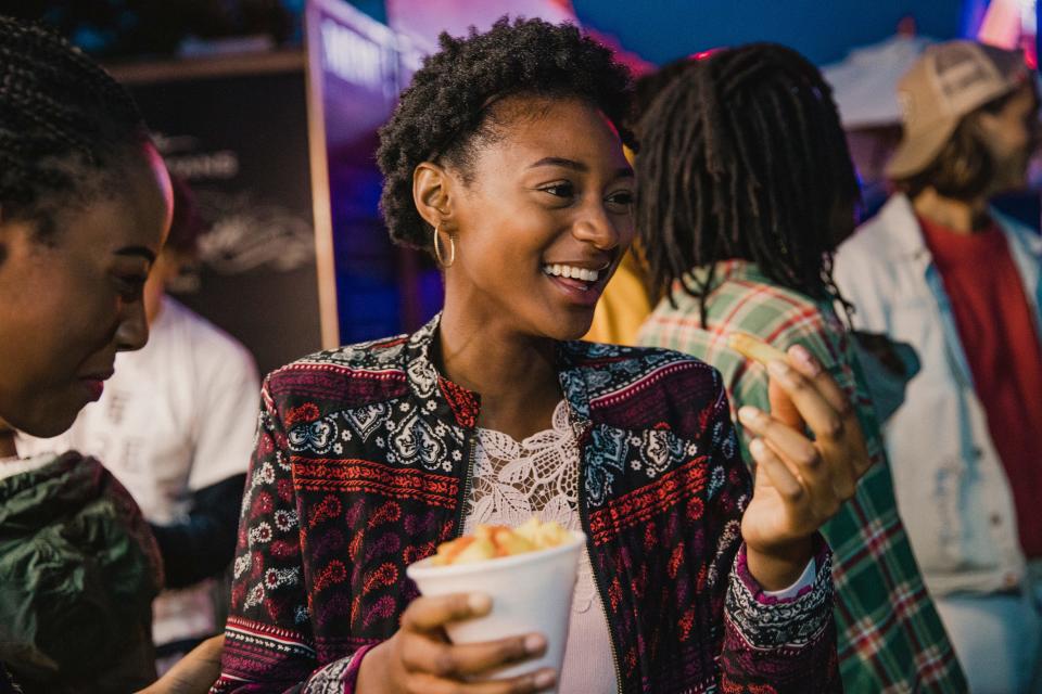 Gen Z woman eating fries from a cone