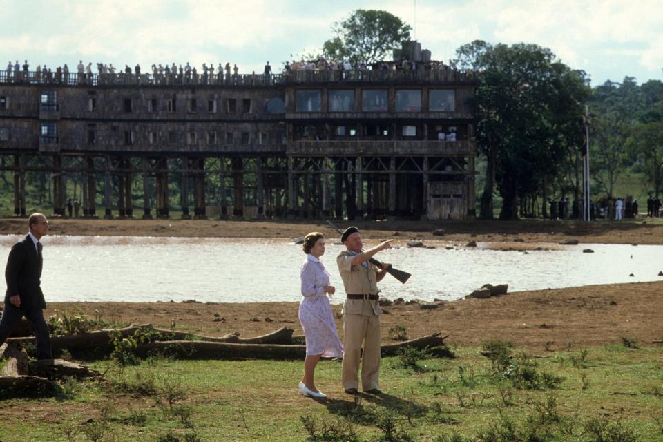 Queen Elizabeth II and Prince Philip are shown around the 'Treetops' hotel by Richard Prickett on November 13, 1983