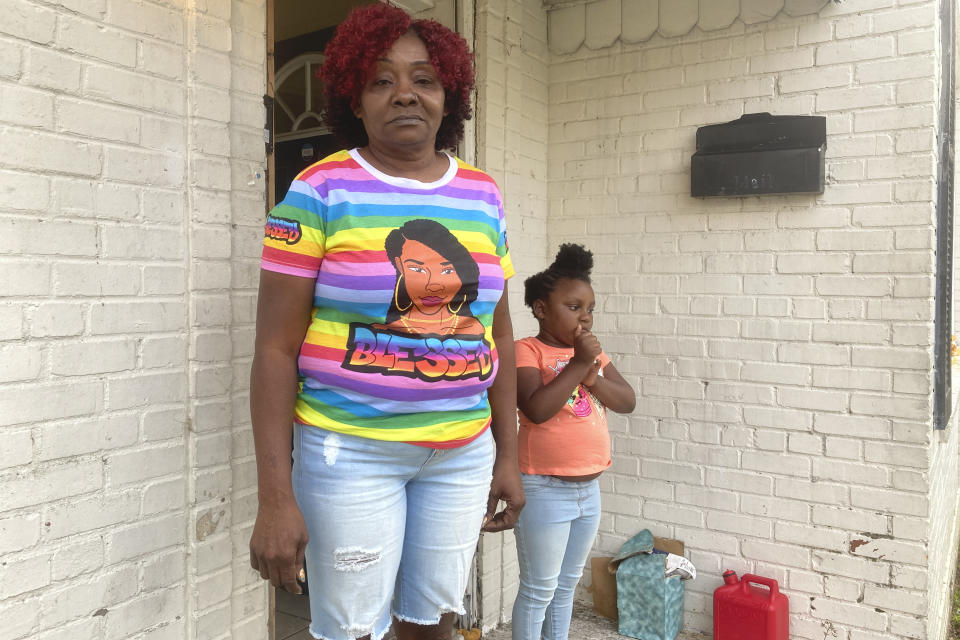 Andrew Brown Jr.'s aunt Martha McCullen and her granddaughter pose for a photo on the stoop of his rental home, Wednesday, April 21, 2021, in Elizabeth City, N.C. Sheriff Tommy Wooten II said at a news conference that a Pasquotank County Sheriff's deputy shot Andrew Brown Jr. about 8:30 a.m., Wednesday, while serving a warrant with the assistance of a nearby sheriff's office in Elizabeth City. (AP Photo/Allen G. Breed)