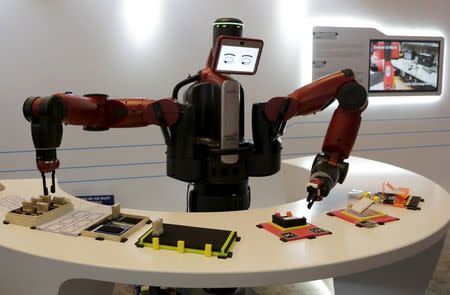 A Baxter robot of Rethink Robotics picks up a business card as it performs during a display at the World Economic Forum (WEF), in China's port city Dalian, Liaoning province, China, September 9, 2015. REUTERS/Jason Lee