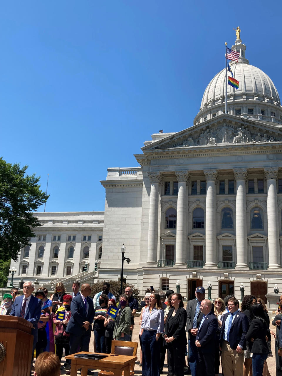 Wisconsin Gov. Tony Evers, at the podium, said he's not ruling out vetoing the entire state budget on Tuesday, June 1, 2021, in Madison, Wis. Evers spoke after a ceremony to raise the rainbow gay pride flag outside the state Capitol in recognition of gay pride month in June in Madison. (AP Photo Scott Bauer)