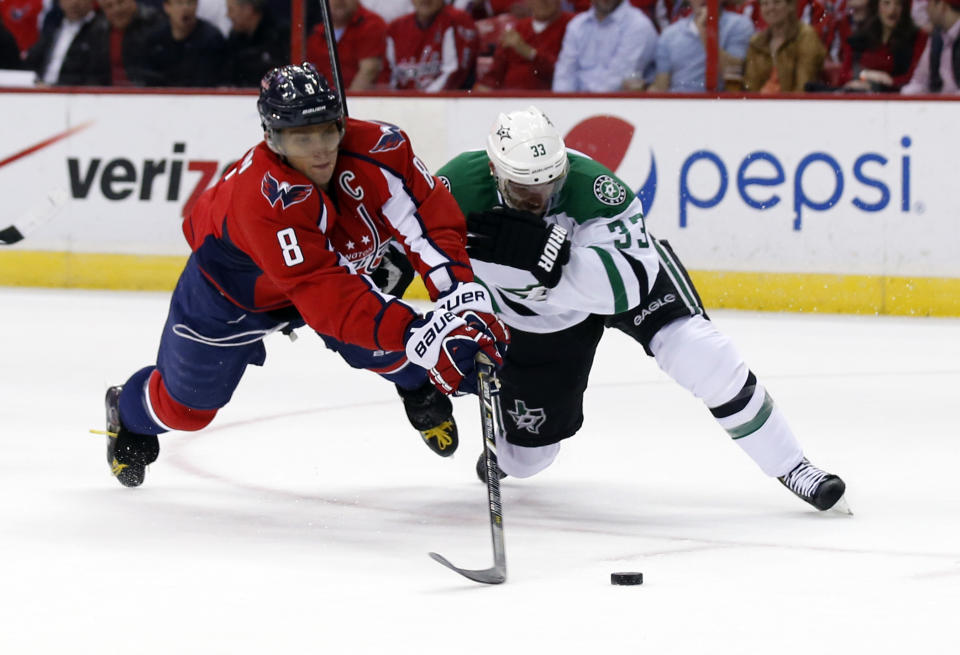 Washington Capitals right wing Alex Ovechkin (8), from Russia, tries to shoot as he is guarded by Dallas Stars defenseman Alex Goligoski (33) in the first period of an NHL hockey game, Tuesday, April 1, 2014, in Washington. (AP Photo/Alex Brandon)