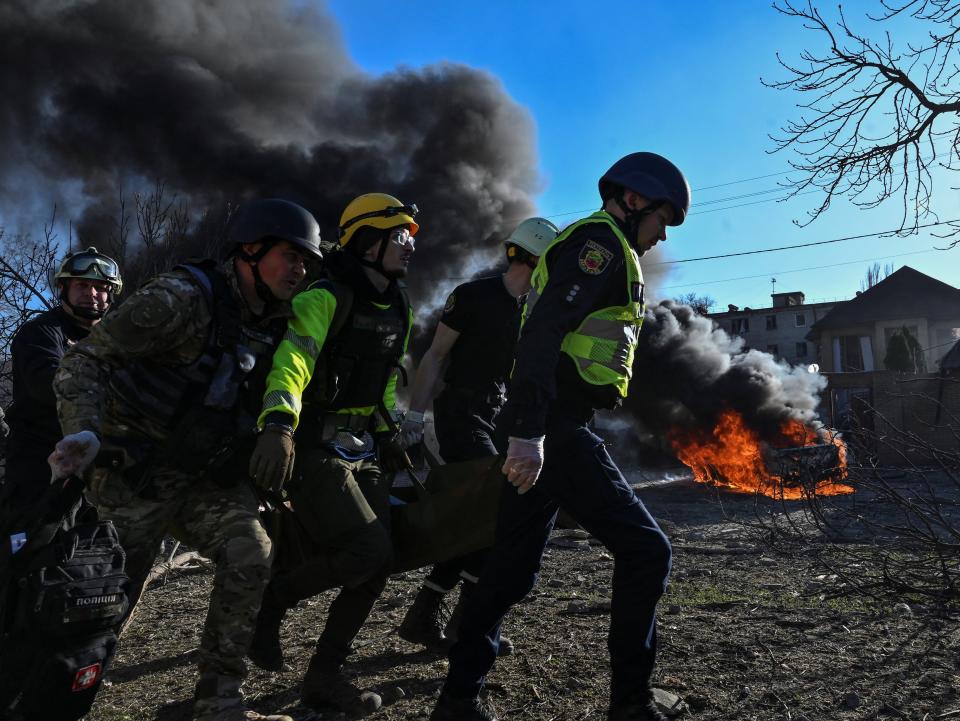 Emergency workers carry an injured woman at the site of a Russian missile strike (Reuters)