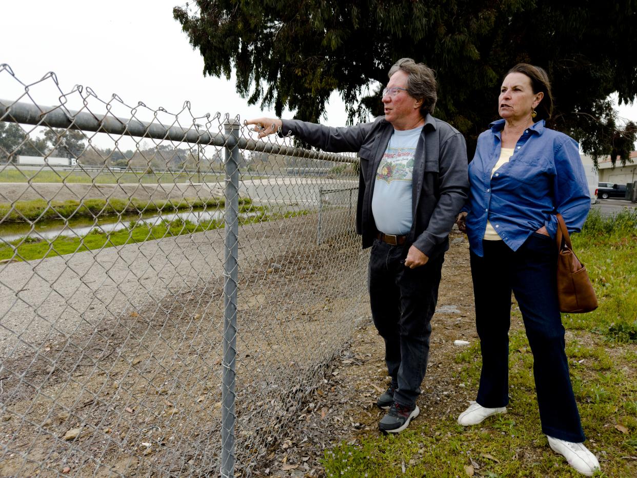 Newbury Park residents Scott Horn and Karen Wilburn overlook a county flood easement along the "Borchard parcel," a 37-acre stretch of undeveloped land. Horn and Wilburn unsuccessfully urged the Thousand Oaks City Council Tuesday to reject a zoning change for the site. On Wednesday, Mason Partners LLC, which owns the parcel, sued Ventura County to end the flood easement.