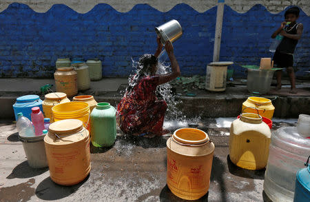 A woman bathes at a roadside municipal tap in a slum area on a hot summer day on the outskirts of Kolkata, India, April 22, 2016. REUTERS/Rupak De Chowdhuri