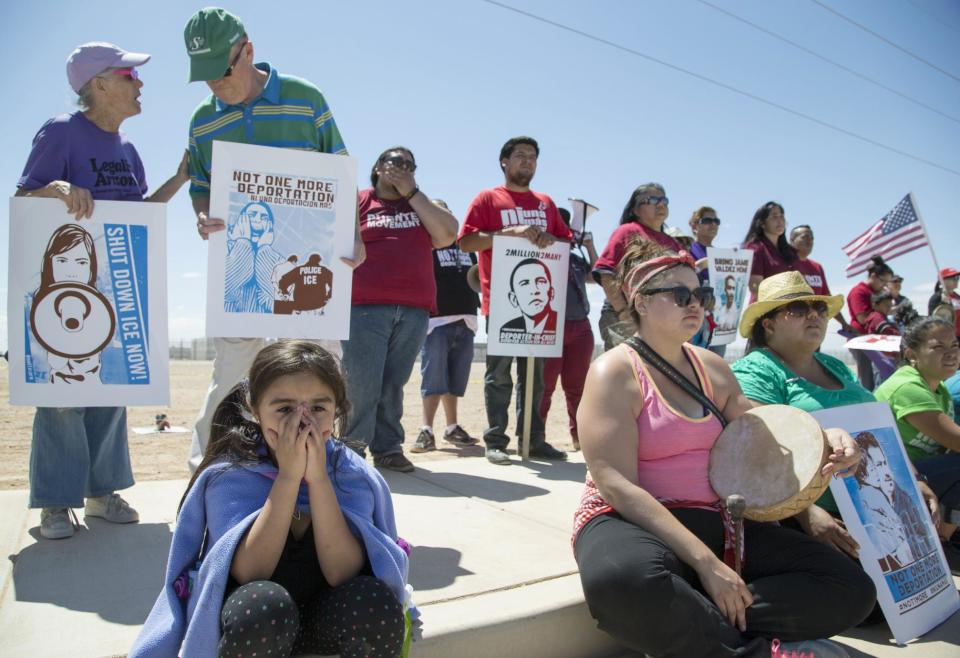 Xitlaly Hernandez, 6, on left, listens to a speech by a supporter of the immigrant advocacy group, Puente Movement, during a rally outside the immigration detention center in Eloy, Ariz., to protest the record numbers of deportations that have taken place under President Barack Obama's administration on Saturday, April 5, 2014. Immigration advocates and supporters rallied Saturday in cities across the country in a renewed effort to push President Barack Obama to put a freeze on deportations. (AP Photo/The Republic, Nick Oza) MARICOPA COUNTY OUT; MAGS OUT; NO SALES