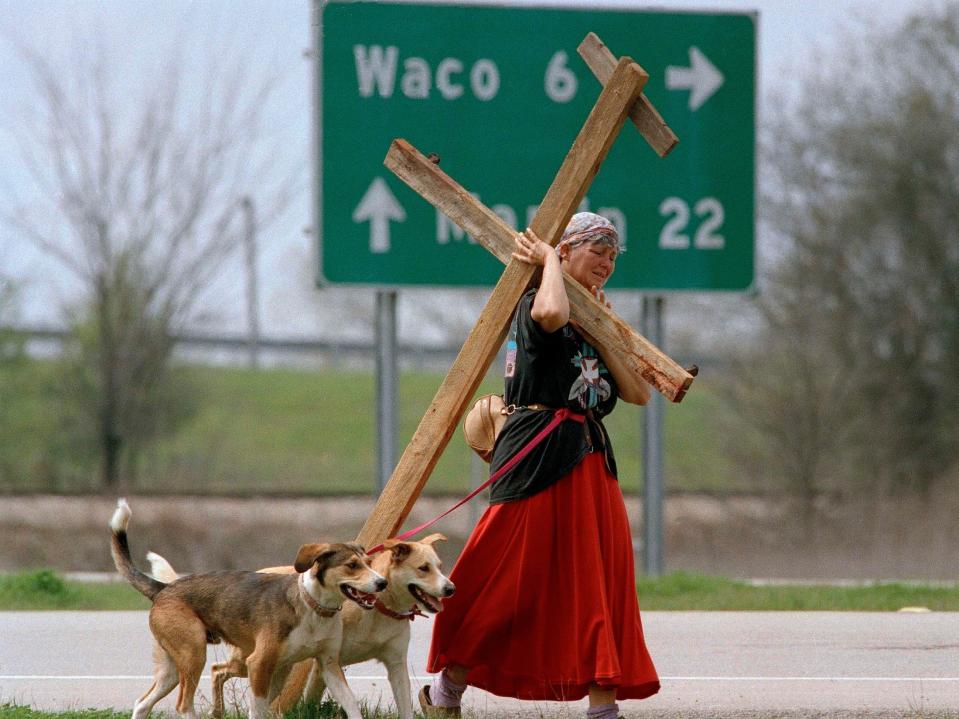 A woman with a cross walked down the road near the Branch Davidian