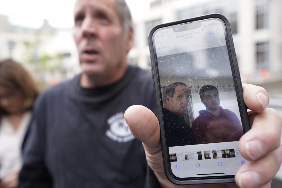 Paul Ventura, left, father of 18-year-old Mateo Ventura, both of Wakefield, Mass., displays a photograph on his cell phone that shows what he describes as a photo of himself and his son Mateo, right, while speaking with reporters outside federal court, Thursday, June 8, 2023, in Worcester, Mass. Mateo Ventura appeared in federal court Thursday on a charge of knowingly concealing the source of material support or resources to a foreign terrorist organization, the U.S. attorney's office in Boston said in a statement. (AP Photo/Steven Senne)