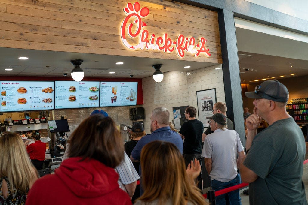 Customers stand in line to order food at a Chick-fil-A restaurant