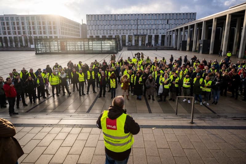 Strikers stand in front of Berlin Brandenburg Airport BER, one of 11 major German airports that have started a one-day strike. Christophe Gateau/dpa