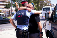 <p>A man embraces a police officer on the spot where five terrorists were shot by police on August 18, 2017 in Cambrils, Spain. (Photo: Alex Caparros/Getty Images) </p>