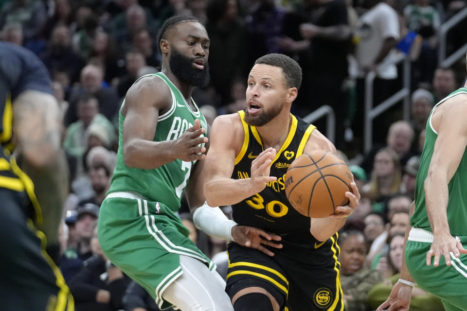 Golden State Warriors guard Stephen Curry (30) looks to pass as Boston Celtics guard Jaylen Brown defends in the first half of an NBA basketball game, Sunday, March 3, 2024, in Boston. (AP Photo/Steven Senne)