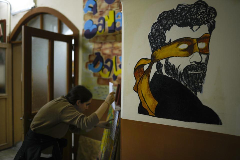 FILE - A woman checks a voting list at a polling station as people wait to vote in Istanbul, Turkey, Sunday, May 28, 2023. With local elections across Turkey days away, legal experts are coaching thousands of volunteer election monitors on the rules they'll need to watch for fraud and ensure a fair vote. (AP Photo/Francisco Seco, File)