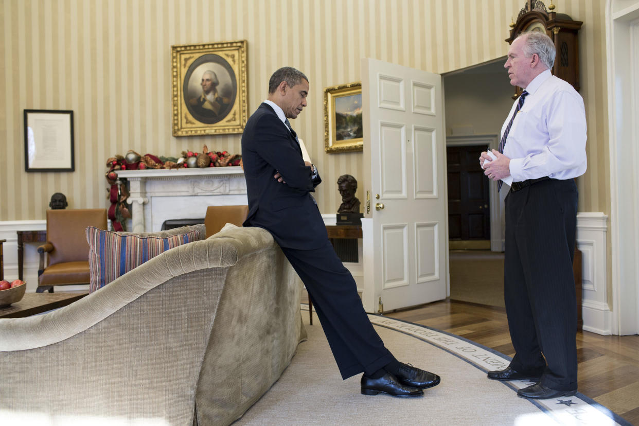 Then-President Barack Obama looking down at the ground in the Oval Office as White House adviser John Brennan briefs him on the details of the shootings at Sandy Hook Elementary School in Newtown, Conn.