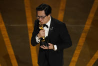 Ke Huy Quan besa el Oscar que ganó como mejor actor de reparto por “Everything Everywhere All at Once” (“Todo en todas partes al mismo tiempo”), el 12 de marzo de 2023 en el Dolby Theatre de Los Ángeles. (Foto AP/Chris Pizzello)