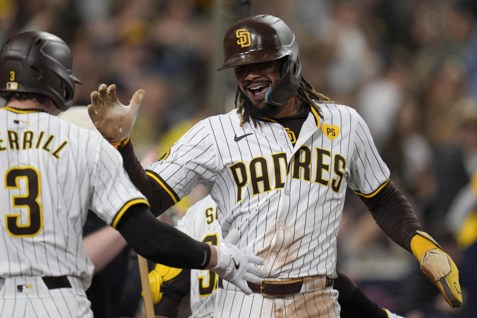 San Diego Padres' Fernando Tatis Jr., right, celebrates with teammate Jackson Merrill after scoring off a two-RBI double by Jake Cronenworth during the fifth inning of a baseball game against the Arizona Diamondbacks, Thursday, June 6, 2024, in San Diego. Arizona Diamondbacks' Lourdes Gurriel Jr. picked up a throwing error on the play. (AP Photo/Gregory Bull)