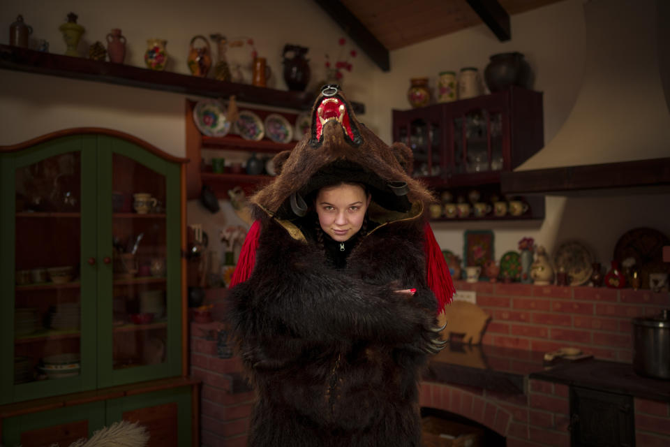 Andra, 15 years-old, a member of the Sipoteni bear pack, poses for a portrait in Comanesti, northern Romania, Wednesday, Dec. 27, 2023. Andra first wore the bear fur costume when she was 6 years-old, gets an adrenaline rush when wearing the outfit and feels the tradition connects the generations and also brings young people together in a meaningful way. (AP Photo/Andreea Alexandru)
