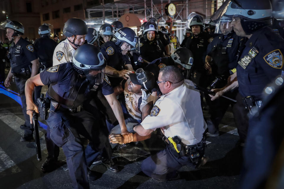 FILE — In this June 4, 2020 file photo, a protester is arrested on New York's Fifth Avenue by NYPD officers during a march, following the death of George Floyd. The New York Police Department was caught off guard by the size and scope of the spring protests sparked by the police killing of George Floyd in Minneapolis and resorted to disorder control tactics that stoked tensions and stifled free speech rights, the city's inspector general said in a report released Friday, Dec. 18, 2020. (AP Photo/John Minchillo, File)