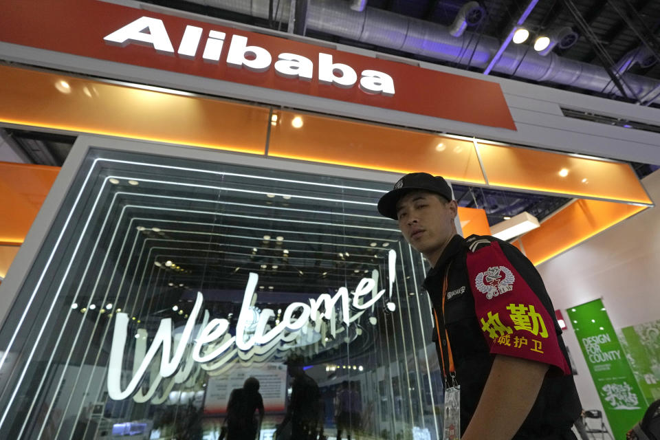 A security guard passes by the Alibaba booth at a trade show in Beijing, China, Tuesday, Sept. 7, 2021. Companies in China would need government approval to transfer important data abroad under proposed rules announced Friday that would tighten Beijing's control over information and might disrupt operations for international corporations. (AP Photo/Ng Han Guan)