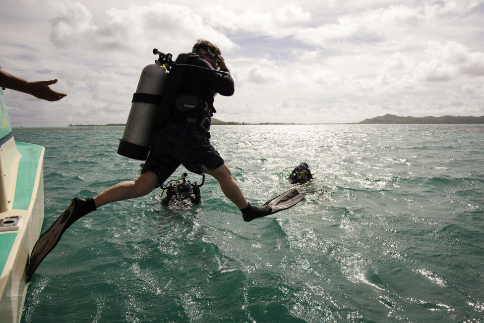 In this Sept. 28, 2015 file photo, Hawaii Institute of Marine Biology director Ruth Gates jumps off a boat into Hawaii's Kaneohe Bay. Gates, who dedicated much of her career to saving the world's fragile and deteriorating coral reefs, has died at age 56. The University of Hawaii, where Gates was the director of the Hawaii Institute of Marine Biology, said Tuesday, Oct. 30, 2018 that the researcher died in Honolulu on Thursday, Oct. 25, 2018. (AP Photo/Caleb Jones, File)