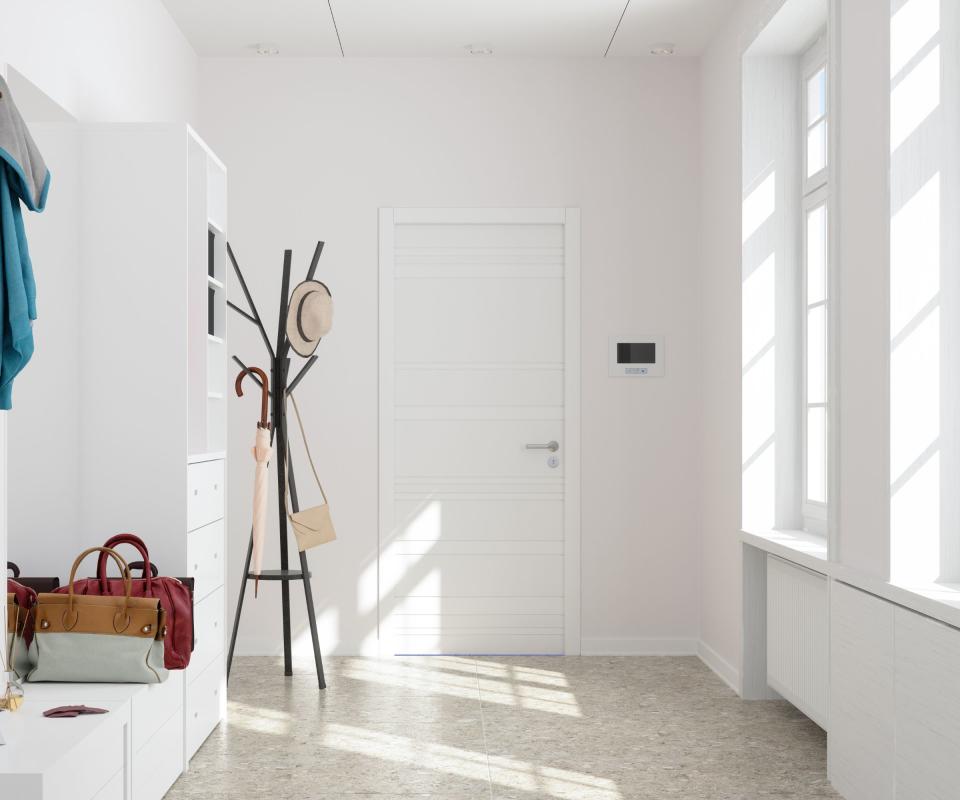 light entryway with white walls and a clothes horse