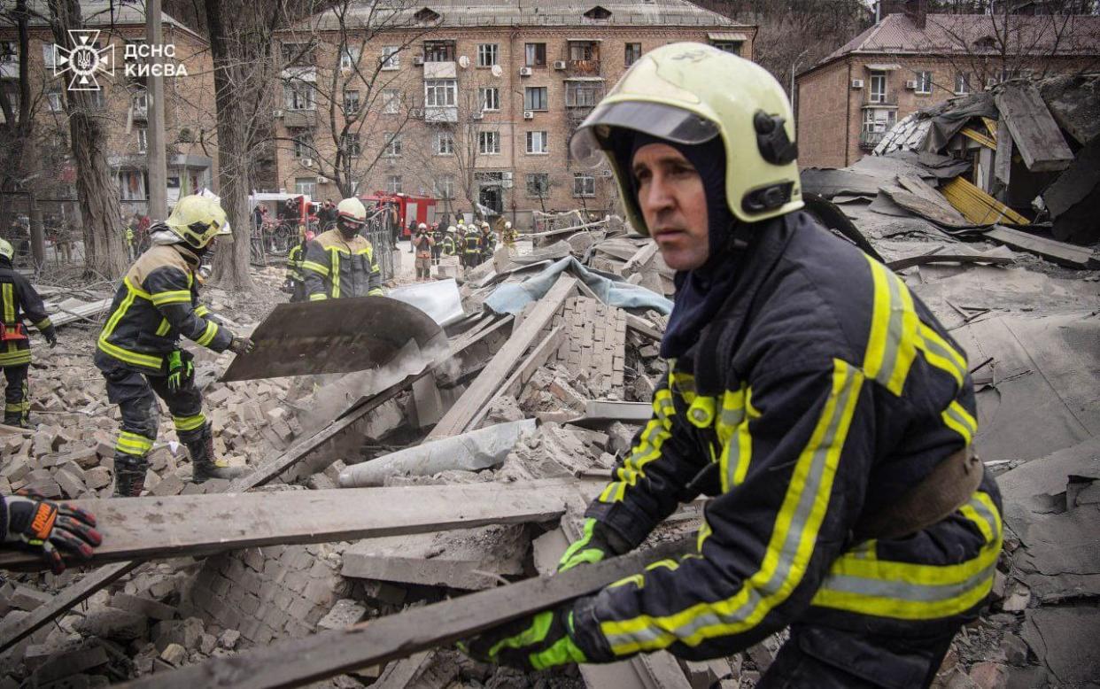 Rescue workers clear a three-story sports hall damaged in a Russian missile attack on the Pechersk district of Kyiv