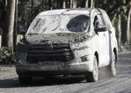 In this Monday, Jan. 13, 2020, photo, an ash-covered vehicle drives down a muddy road as Taal volcano continues to erupt in Tagaytay, Cavite province, southern Philippines. Red-hot lava gushed out of a volcano near the Philippine capital on Monday, as thousands of people fled the area through heavy ash. Experts warned that the eruption could get worse and plans were being made to evacuate hundreds of thousands. (AP Photo/Aaron Favila)