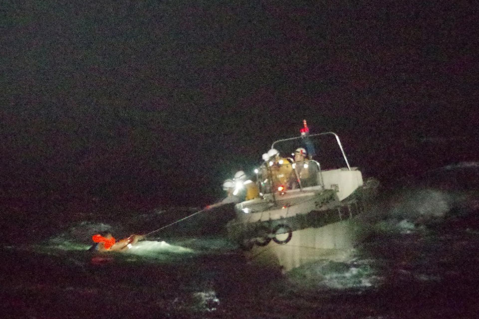 In this photo released by the 10th Regional Japan Coast Guard Headquarters, a Filipino crewmember of a Panamanian cargo ship is rescued by Japanese Coast Guard members in the waters off the Amami Oshima, Japan Wednesday, Sept. 2, 2020. Japanese rescuers have safely plucked the crewmember from the sea while searching for the cargo ship carrying more than 40 crew and thousands of cows went missing after sending a distress call off the southern Japanese island. (The 10th Regional Japan Coast Guard Headquarters via AP)