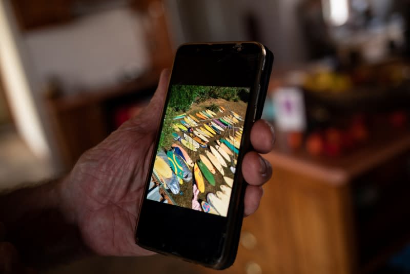 Australian surfer David Ford shows a photo on his phone of a part of his vintage surfboard collection that was destroyed in the recent bushfires in Lake Conjola