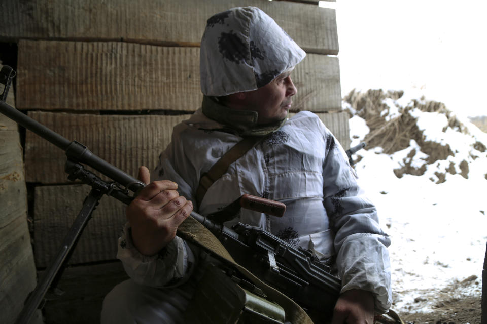 A serviceman holds his machine-gun in a shelter on the territory controlled by pro-Russian militants at frontline with Ukrainian government forces in Slavyanoserbsk, Luhansk region, eastern Ukraine, Tuesday, Jan. 25, 2022. Ukraine's leaders sought to reassure the nation that a feared invasion from neighboring Russia was not imminent, even as they acknowledged the threat is real and prepared to accept a shipment of American military equipment Tuesday to shore up their defenses. (AP Photo/Alexei Alexandrov)