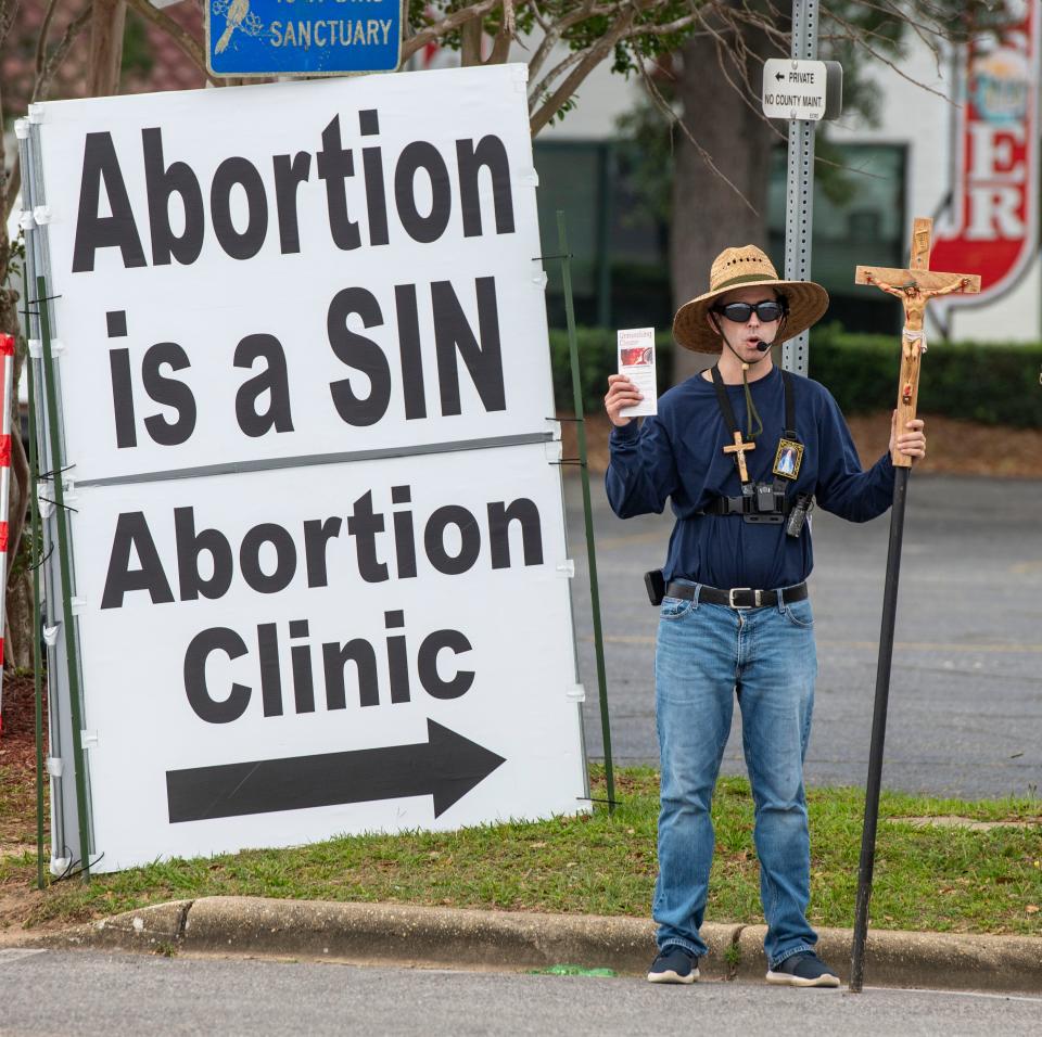 Anti-abortion protesters picket on Davis Highway near the American Family Planning abortion clinic in Pensacola on May 21, 2022, as the nation awaits a pivotal ruling from the Supreme Court that could overturn Roe v. Wade.