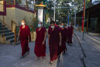 Exile Tibetan Buddhist monks wear masks as protection against the coronavirus as they circumambulate the residence of Tibetan spiritual leader the Dalai Lama in Dharmsala, India, Sunday, Sept. 27, 2020. (AP Photo/Ashwini Bhatia)