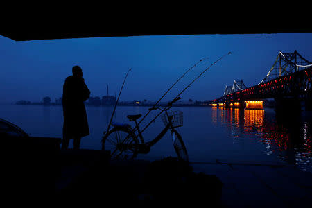 A man looks across Yalu River towards North Korea as he stands next to the bridge that connects China's Dandong, Liaoning province and North Korea's Sinuiju, September 10, 2016. REUTERS/Thomas Peter/File Photo