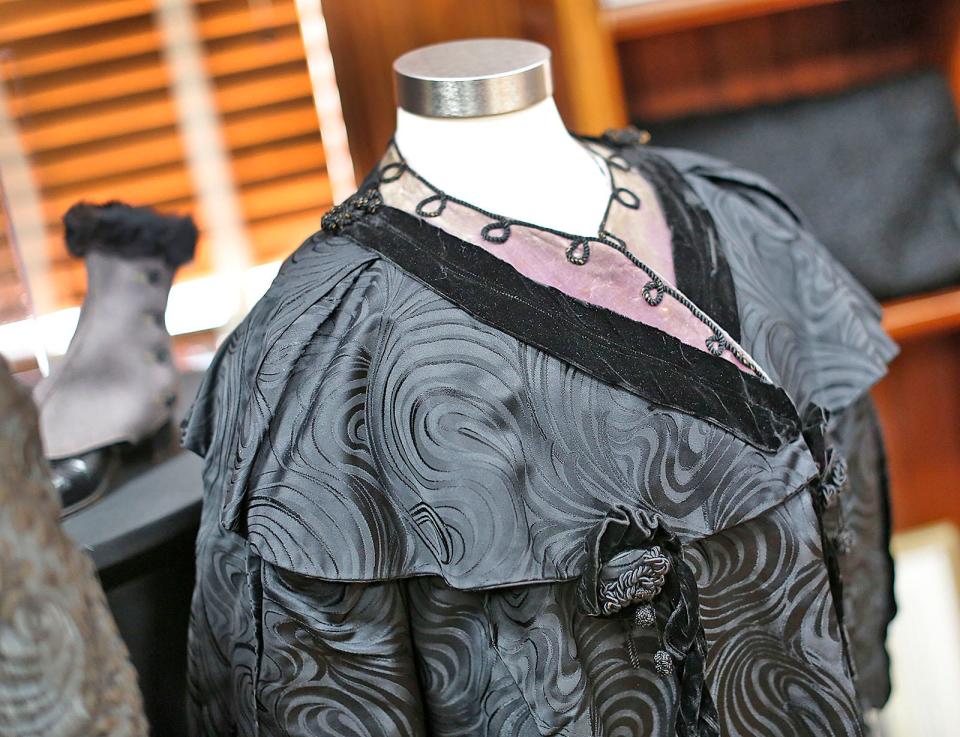 This 1900-10 black silk brocade coat with a purple collar is part of the exhibit "Baby, It's Cold Outside" featuring women's capes, coats and winterwear at the Cohasset Historical Society. Brocade is a decorative, patterned woven fabric.