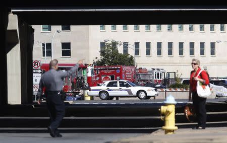 A Pentagon police officer directs a woman away from a closed-off Pentagon parking lot where a woman who recently traveled to Africa vomited, in Washington October 17, 2014. REUTERS/Kevin Lamarque