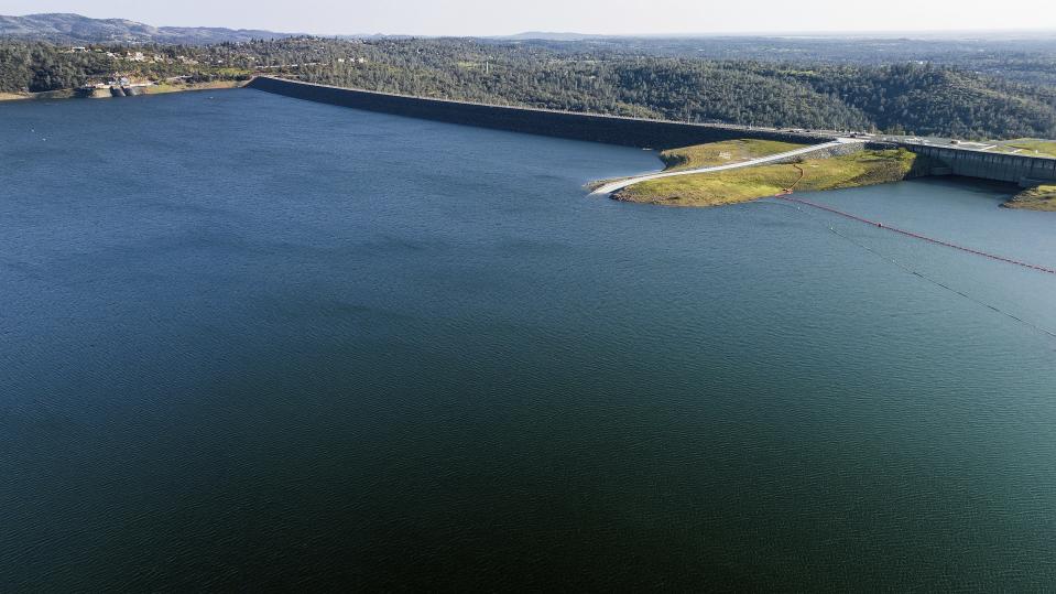 FILE - The Oroville Dam, top right, holds back water at Lake Oroville on March 25, 2023, in Butte County, California. California ended its 2022-23 water year on Saturday, Sept. 30, 2023. After years of severe drought, the reservoirs in the state water project ended the year at 128% of their historical average. That includes Lake Oroville. (AP Photo/Noah Berger, File)