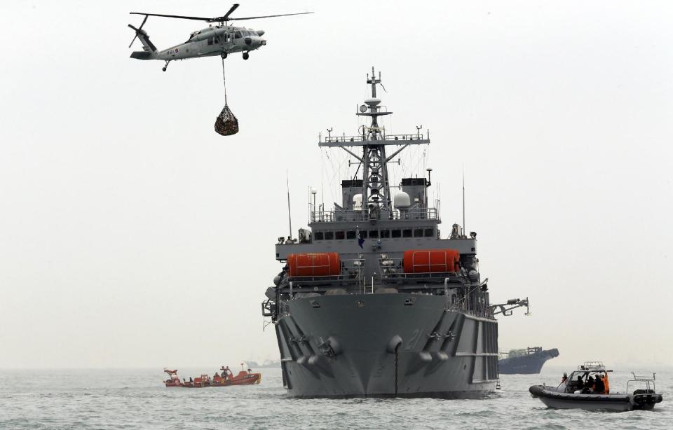 South Korean Navy and Coast Guard personnel on a ship and boats search for missing passengers aboard the sunken ferry Sewol in the water off the southern coast near Jindo, South Korea, Friday, April 18, 2014. Investigations into South Korea's ferry disaster focused on the sharp turn it took just before it started listing and on the possibility that a quicker evacuation order by the captain could have saved lives, officials said Friday, as rescuers scrambled to find some 270 people still missing and feared dead. (AP Photo/Yonhap) KOREA OUT