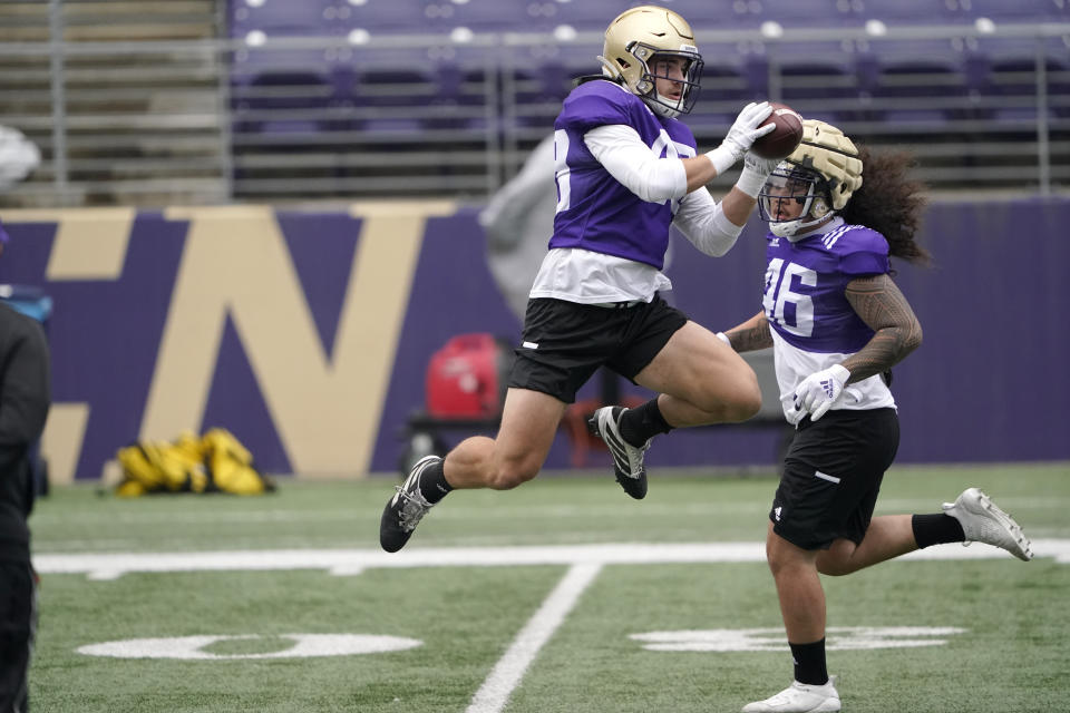 Washington linebacker Jackson Sirmon leaps to make a catch during NCAA college football practice, Friday, Oct. 16, 2020, in Seattle. (AP Photo/Ted S. Warren)