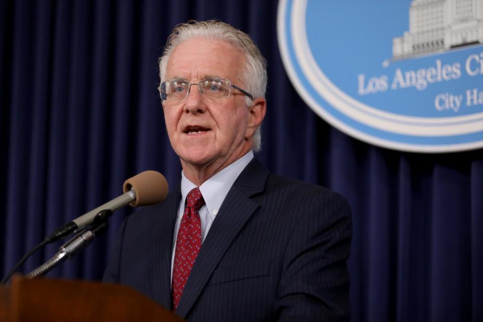 A man in a suit speaks into a microphone