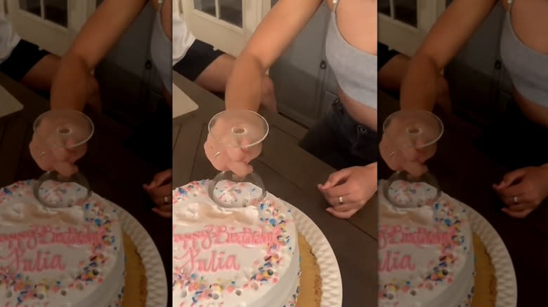 cutting cake with wine glass