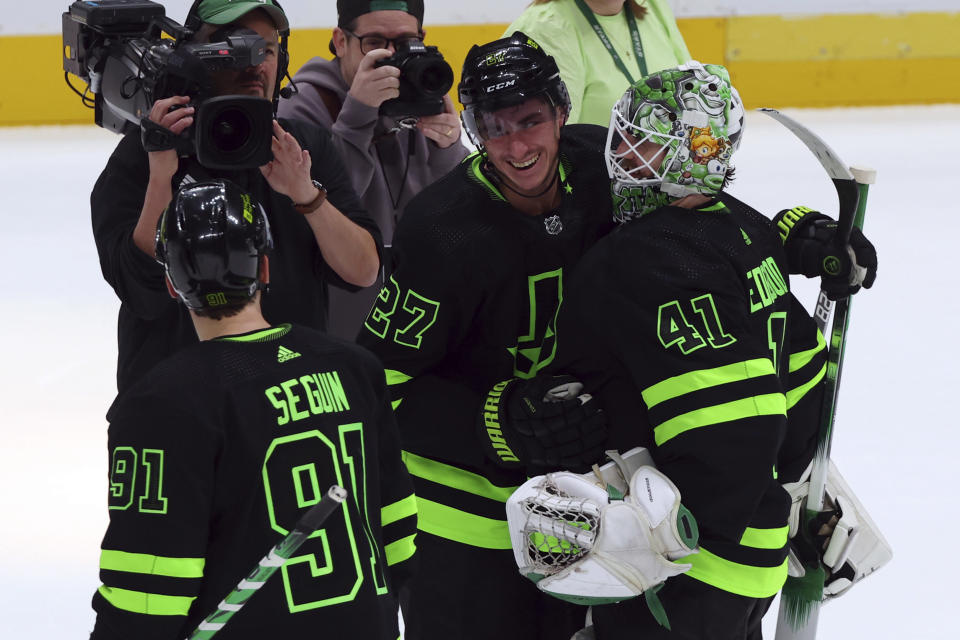 Dallas Stars left wing Mason Marchment (27) celebrates with goaltender Scott Wedgewood (41) and center Tyler Seguin (91) after their win over the Chicago Blackhawks in an NHL hockey game Sunday, Dec. 31, 2023, in Dallas. (AP Photo/Richard W. Rodriguez)