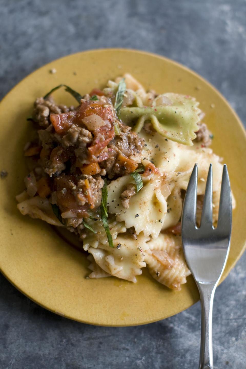 This Dec. 2, 2013 photo shows five spice pork bolognese pasta in Concord, N.H. This Bolognese is mostly effortless. You can make it even more so by using the food processor to chop your vegetables. Just toss them all in at once, then pulse until finely chopped. As for the meat, pork is delicious, but feel free to substitute beef, veal or turkey. (AP Photo/Matthew Mead)