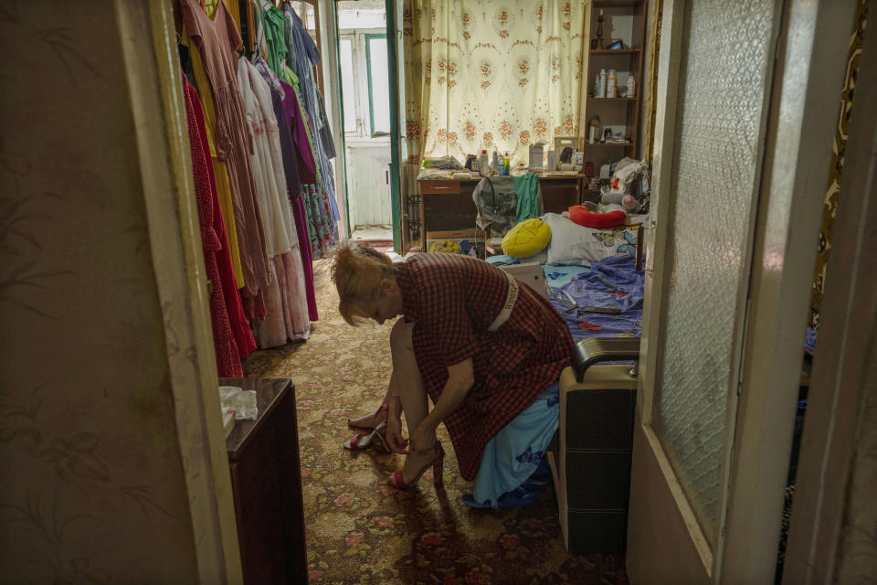 Medic volunteer Nataliia Voronkova puts on her high-heeled shoes as she prepares to give a medical tactical training course to soldiers and paramedics, in her apartment in Pokrovsk, eastern Ukraine, Friday, July 22, 2022. Voronkova has dedicated her life to aid distribution and tactical medical training for soldiers and paramedics, working on front line of the Donetsk region since the war began in 2014. (AP Photo/Nariman El-Mofty)